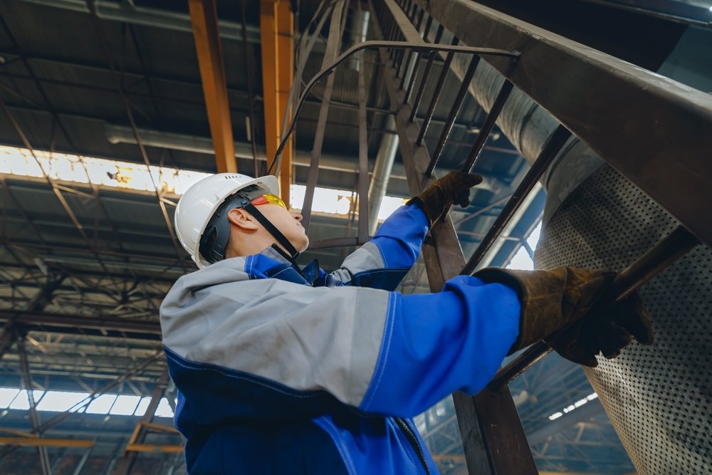 Male,Engineer,Inspecting,Carries,Out,High,Altitude,Work,,Climbs,Ladders.
